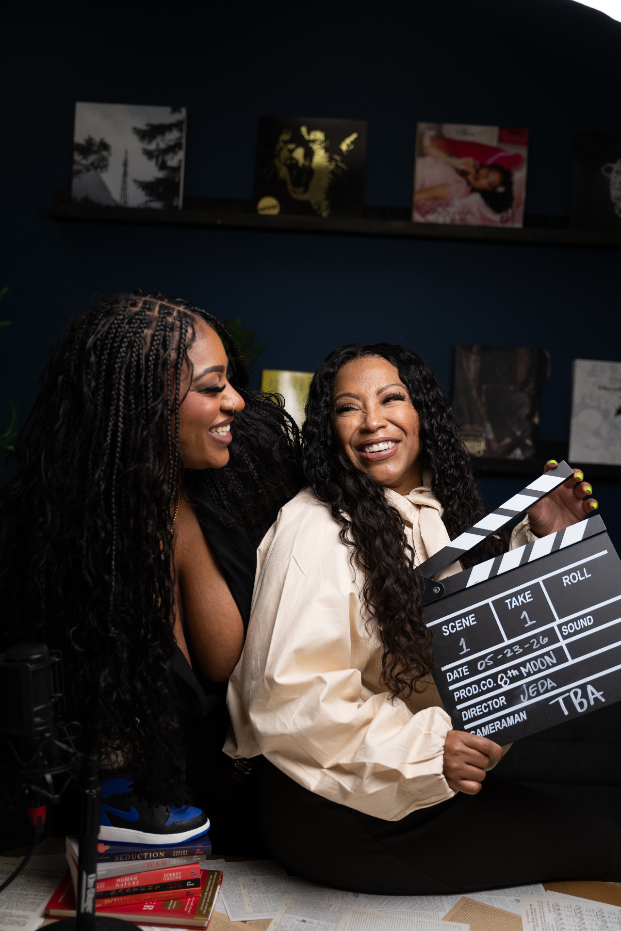 Malaysia Genjiia and Lauresha Z. Hawkins laughing while holding an 8th Moon clapperboard in the studio